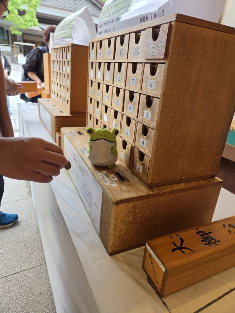 Frog vid omikuji-lådan i Meijitemplet i Tokyo