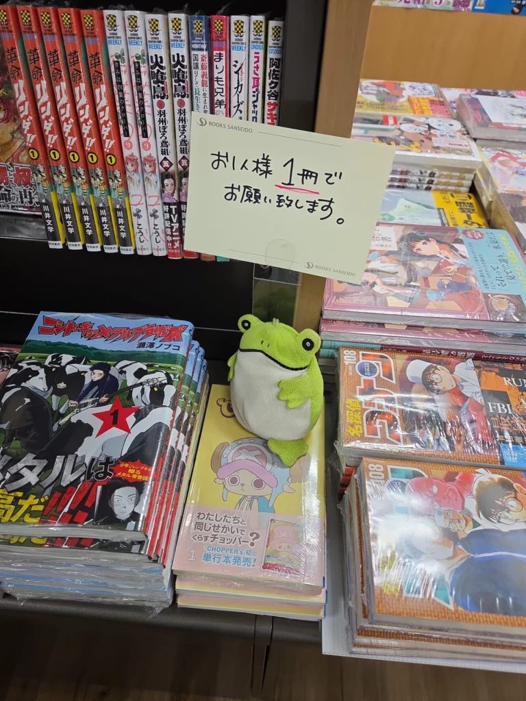 Frog sitter på en hög Chopper-mangor i en japansk bokhandel